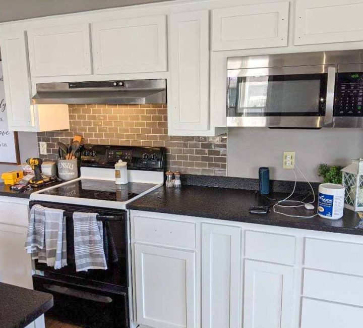 white kitchen cabinet with black counter top